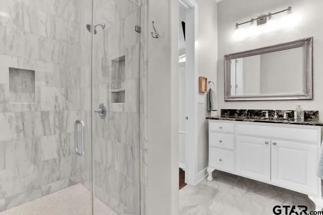 a bathroom with a granite countertop sink and a mirror