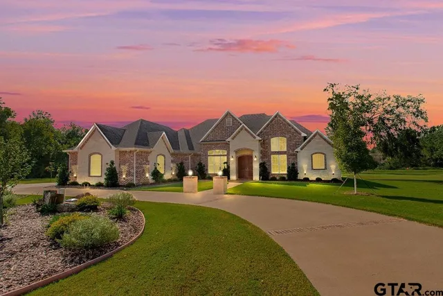 a front view of a house with a yard and trees