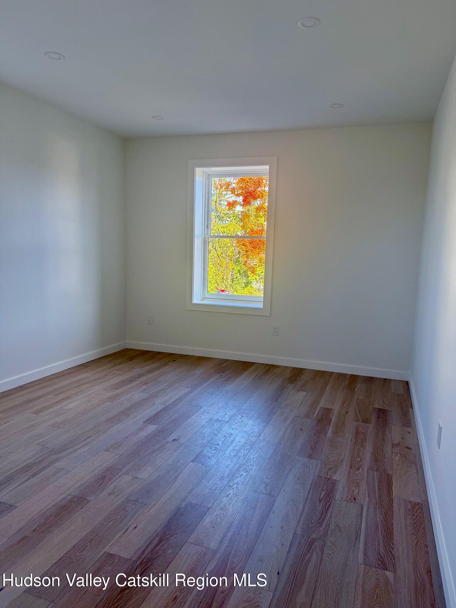 1 Main Street, Unit 2 Kingston, NY 12401 - Photo 11 of 14 an empty room with wooden floor and windows