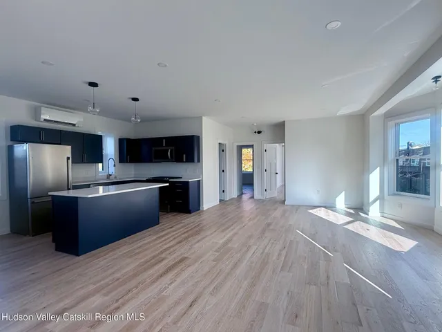 a large kitchen with stainless steel appliances granite countertop a refrigerator and a sink