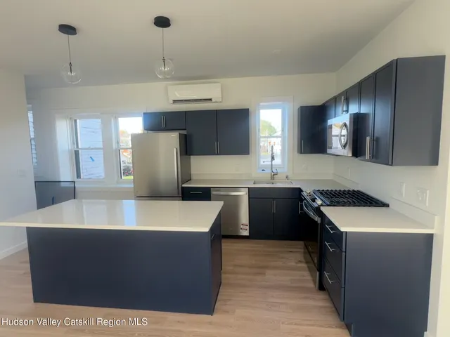 a large kitchen with stainless steel appliances granite countertop a sink a stove and a refrigerator