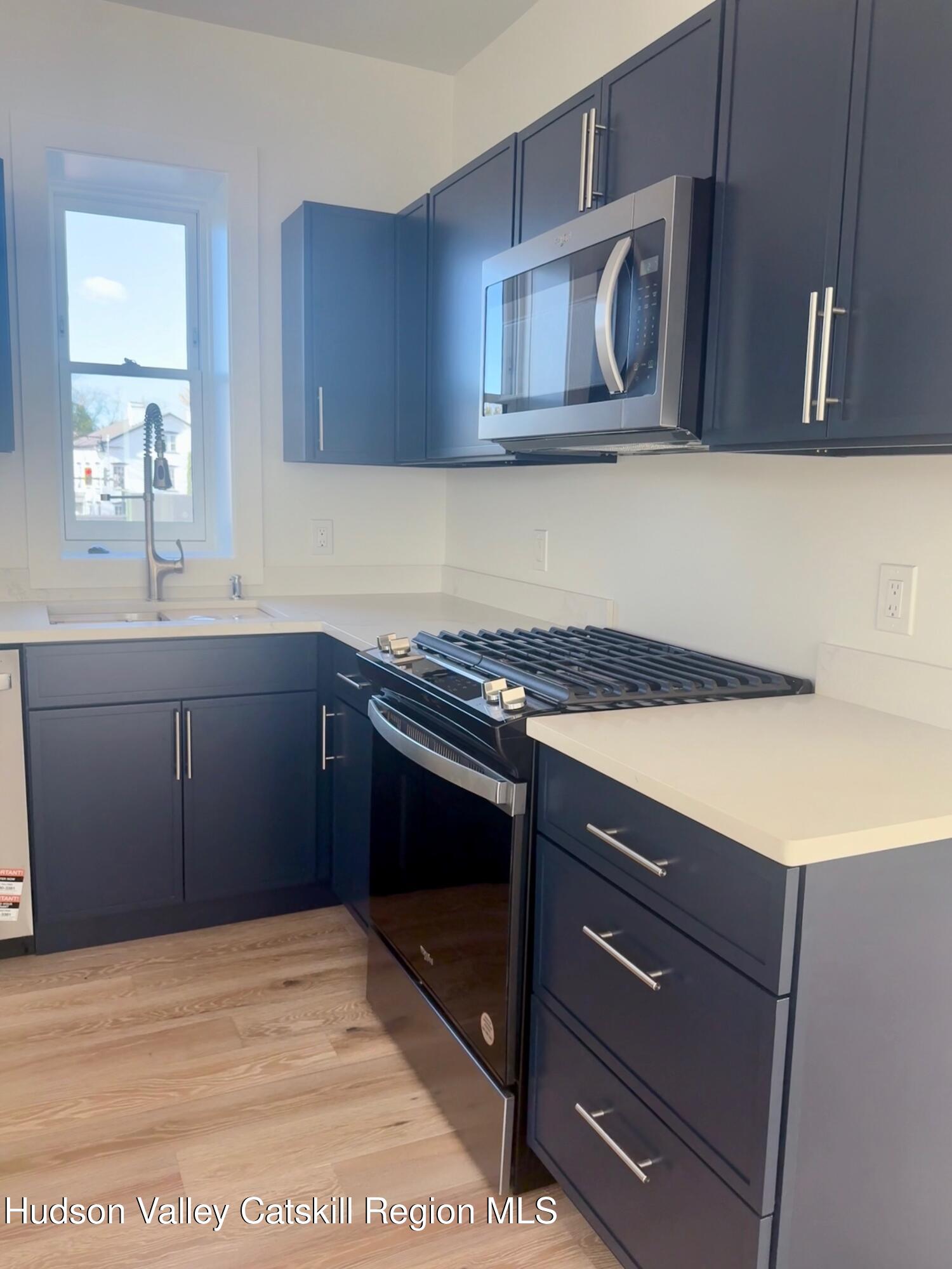 1 Main Street, Unit 2 Kingston, NY 12401 - Photo 5 of 14 a kitchen with a sink stove top oven and cabinets