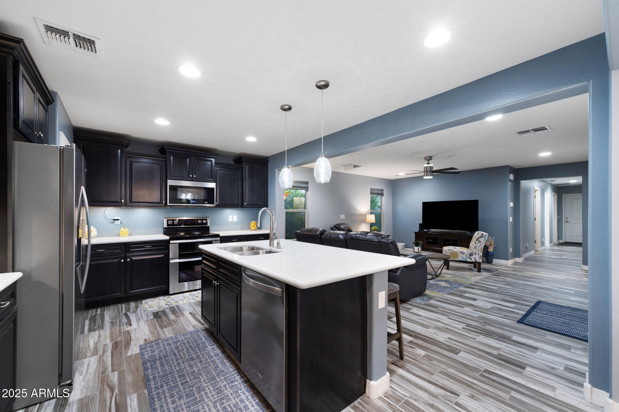 1755 East Mesquite Avenue Apache Junction, AZ 85119 - Photo 4 of 17 a large kitchen with stainless steel appliances a stove a sink dishwasher and a refrigerator with wooden floor