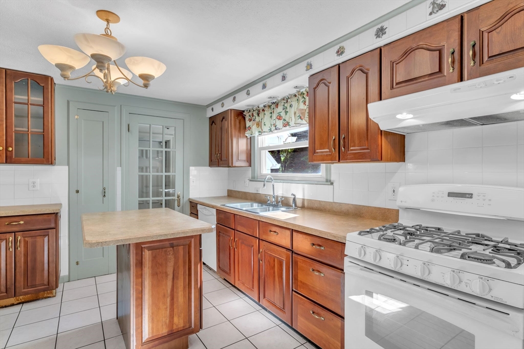 1271 Plumtree Road Springfield, MA 01119 - Photo 13 of 41 a kitchen with stainless steel appliances a stove a sink dishwasher and cabinets with wooden floor