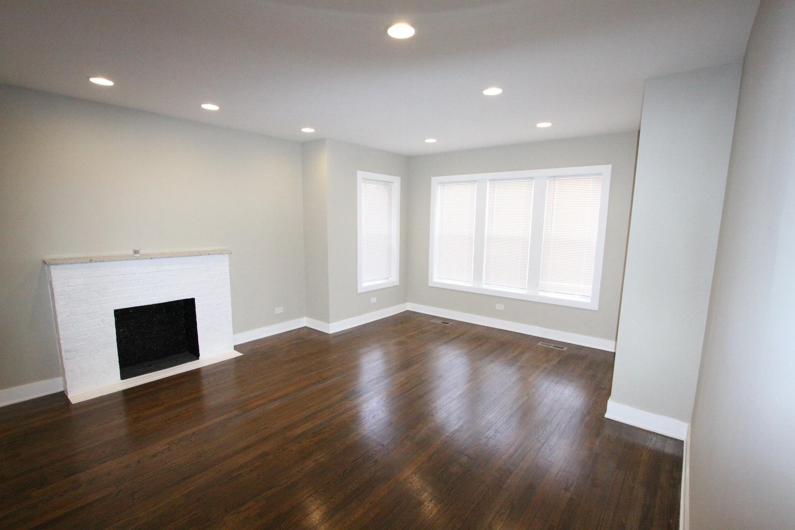 111 West 74th Street Chicago, IL 60621 - Photo 3 of 10 a view of an empty room with wooden floor fireplace and a window