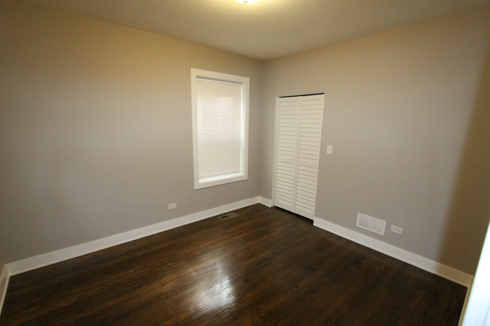 111 West 74th Street Chicago, IL 60621 - Photo 7 of 10 an empty room with wooden floor and windows