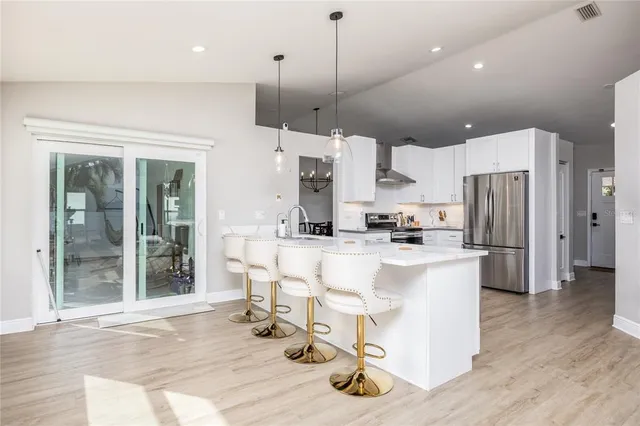 a large white kitchen with lots of counter space and refrigerator