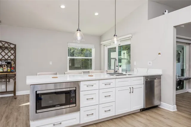 a kitchen with a stove and a wooden floor