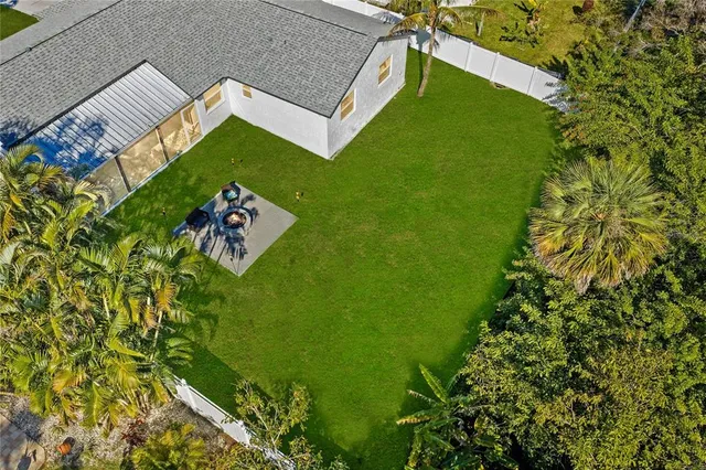 a view of a house with a big yard and large trees