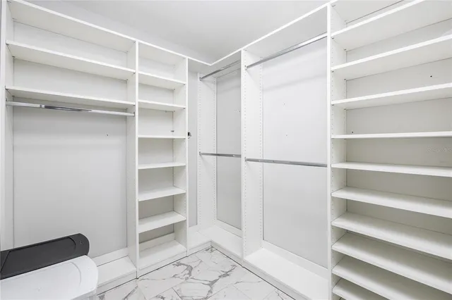 a view of walk in closet with empty racks