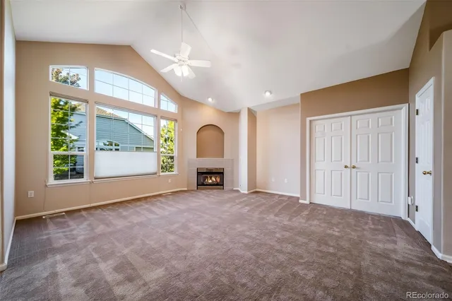 a view of an empty room with a fireplace and a window