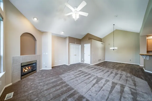 a living room with stainless steel appliances furniture a rug and a wooden floor