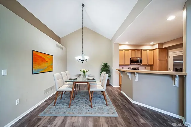a view of kitchen and empty room with wooden floor