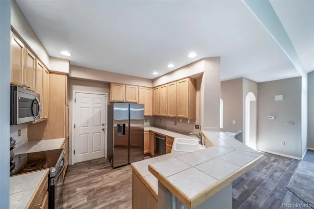 a kitchen with stainless steel appliances kitchen island granite countertop a stove and a sink