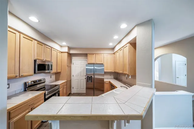 a kitchen with stainless steel appliances granite countertop a refrigerator stove and microwave