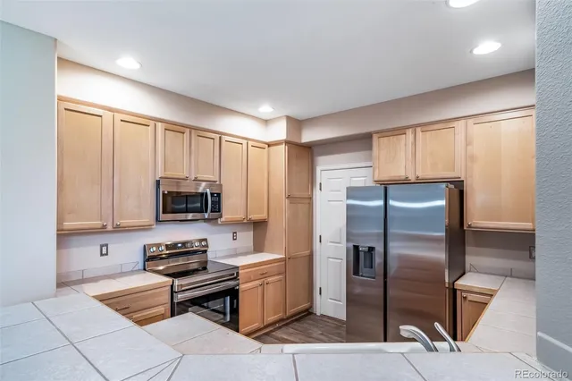a kitchen with stainless steel appliances white cabinets and a stove top oven