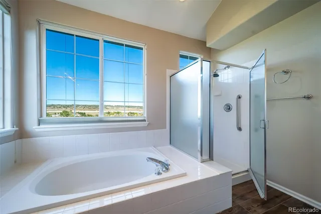 a large bathroom with a tub sink and mirror
