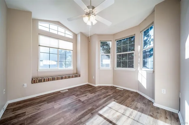 a view of an empty room with a window and wooden floor