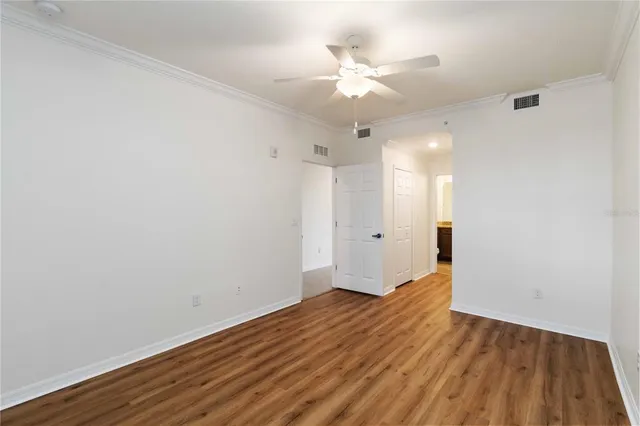 a view of an empty room with wooden floor