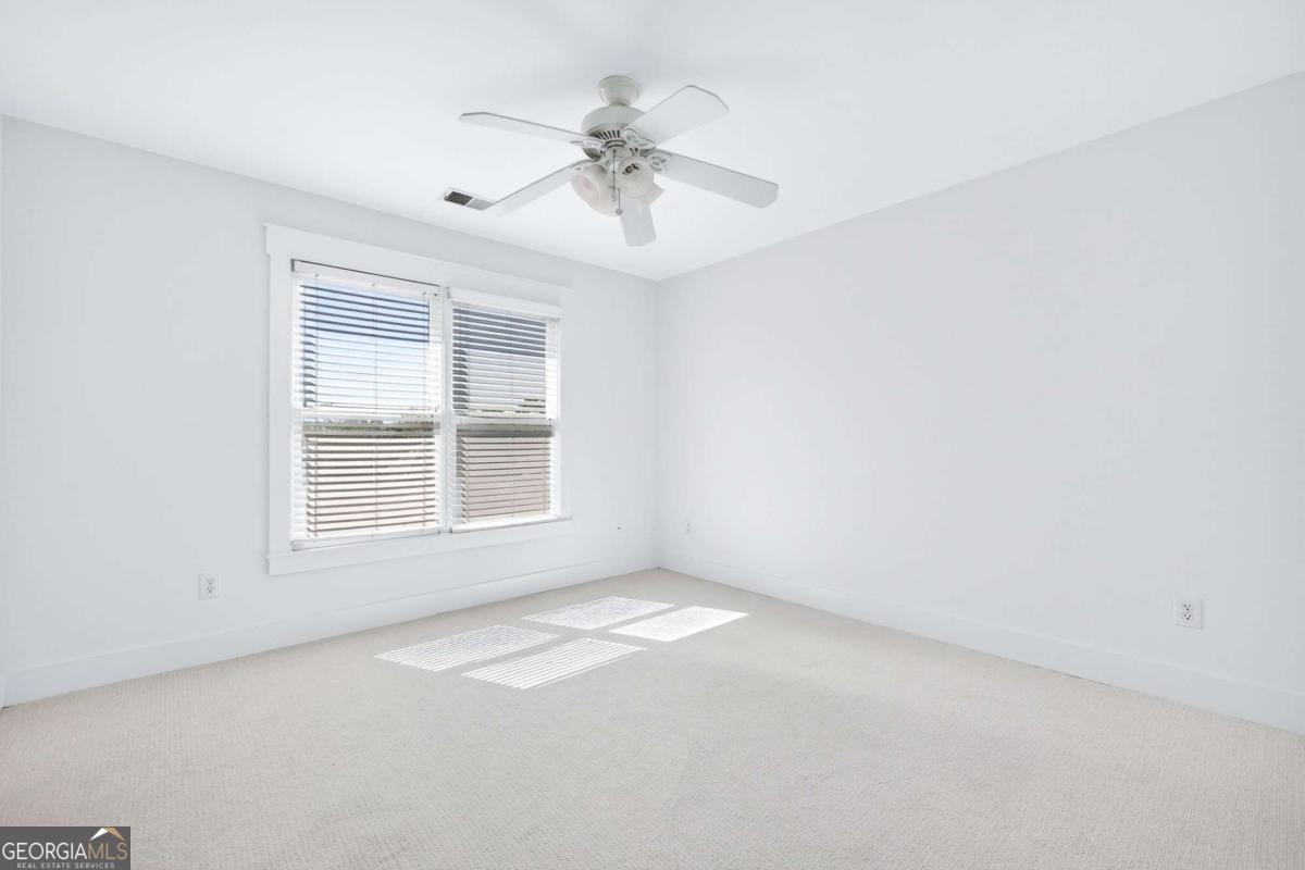 4492 Oakdale Road Southeast Smyrna, GA 30080 - Photo 21 of 37 an empty room with a chandelier fan and windows