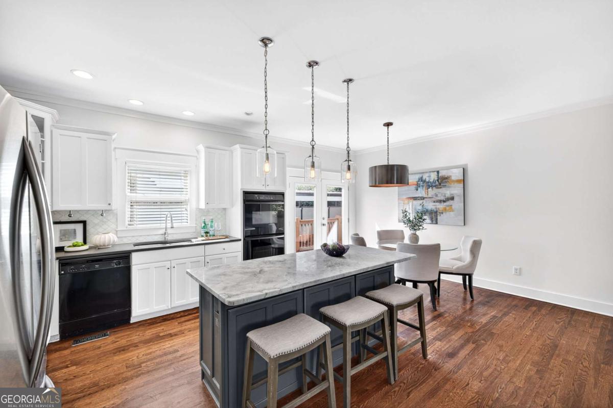 4492 Oakdale Road Southeast Smyrna, GA 30080 - Photo 8 of 37 a kitchen with stainless steel appliances granite countertop a kitchen island a stove a table and chairs