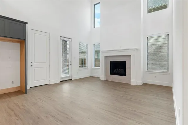 an empty room with windows and fireplace