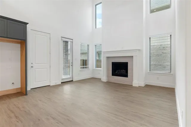 an empty room with windows and fireplace
