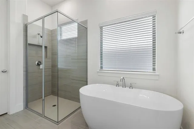 a white bath tub sitting next to a shower