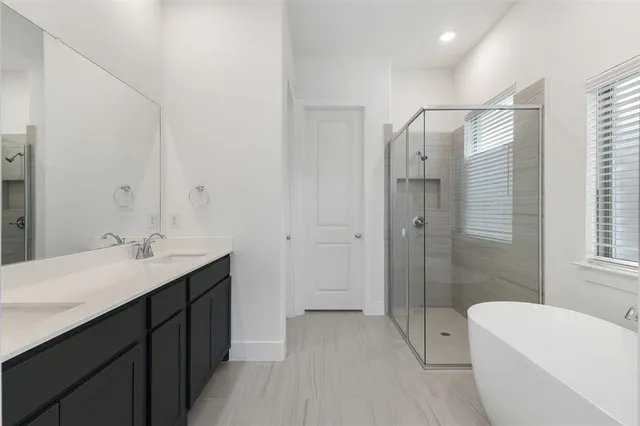 a bathroom with a double vanity sink toilet and shower