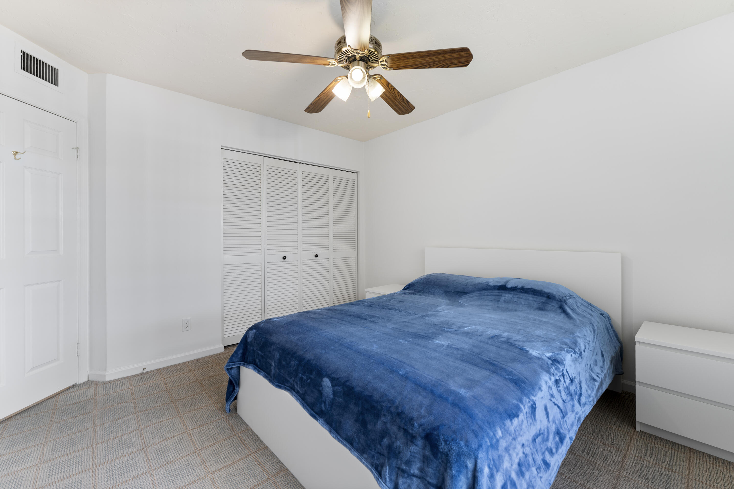 7507 La Paz Boulevard, Unit 407 Boca Raton, FL 33433 - Photo 18 of 31 a bedroom with a bed and a ceiling fan