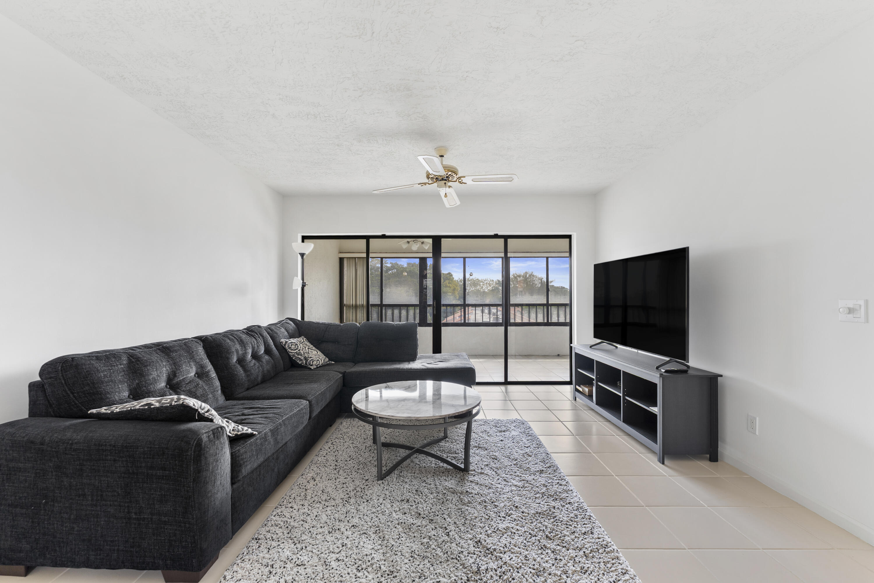 7507 La Paz Boulevard, Unit 407 Boca Raton, FL 33433 - Photo 5 of 31 a living room with furniture and a flat screen tv