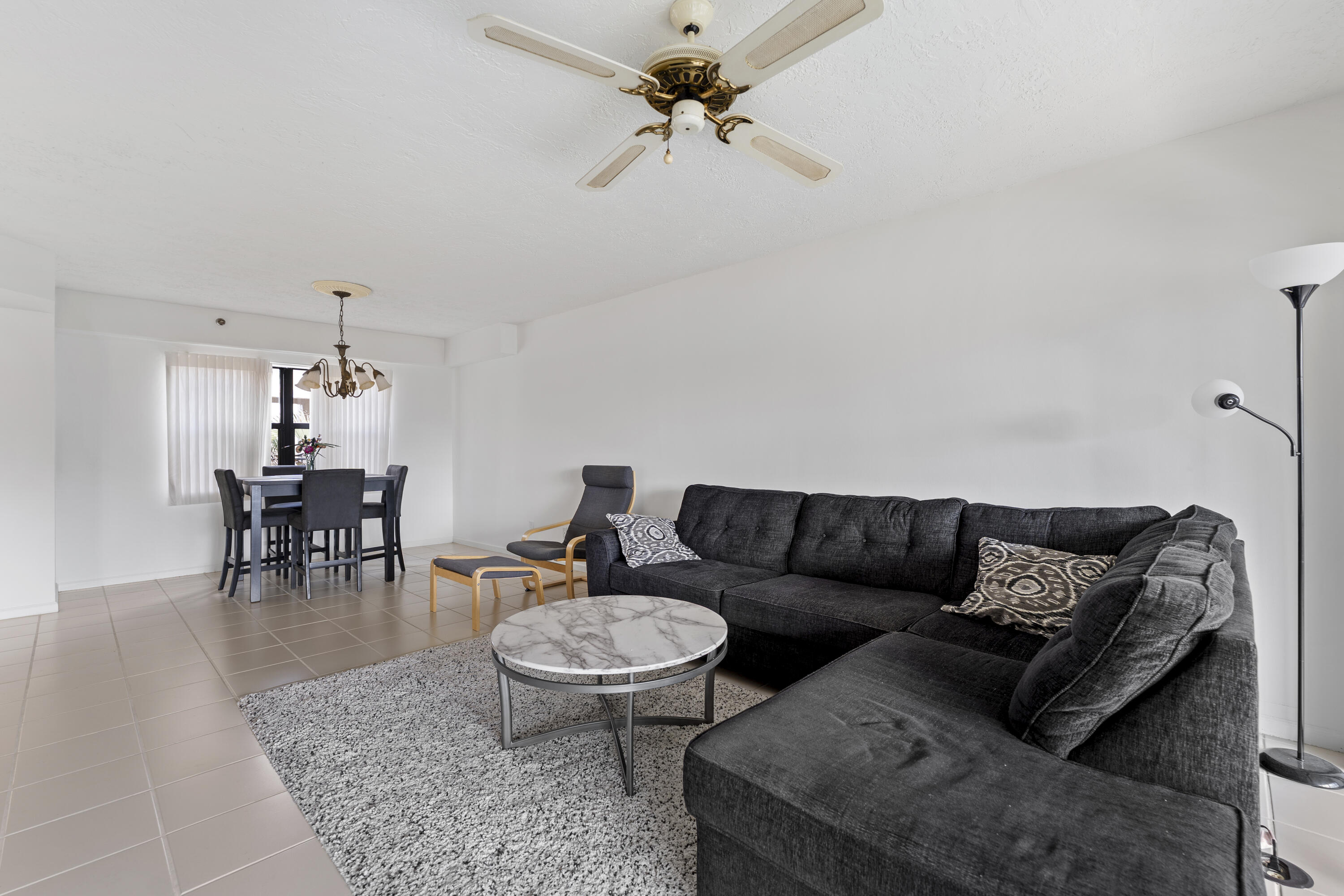 7507 La Paz Boulevard, Unit 407 Boca Raton, FL 33433 - Photo 6 of 31 a living room with furniture a rug and a chandelier
