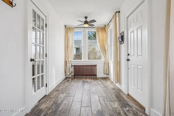 a view of an empty room with wooden floor
