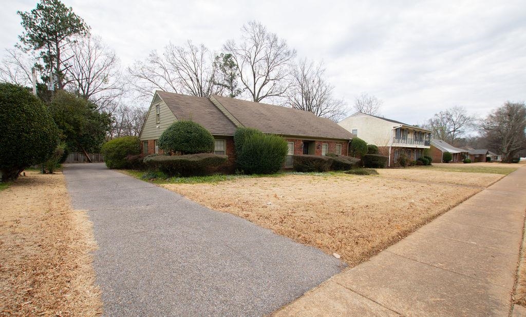a front view of house with yard and trees around