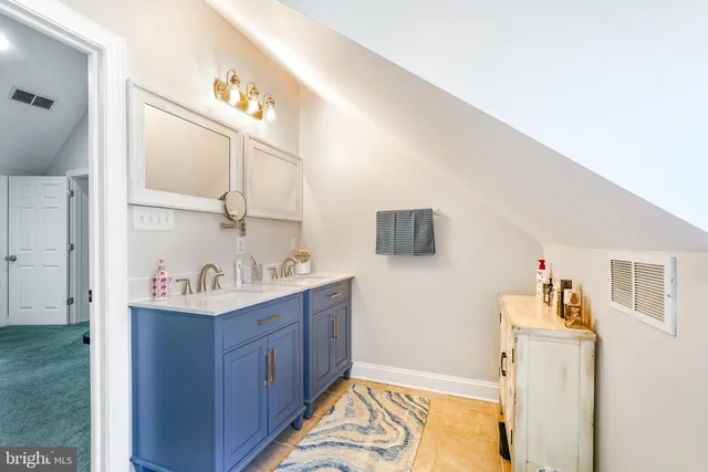a bathroom with a toilet sink vanity and shower
