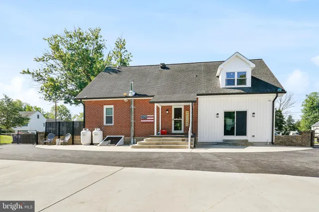 a large kitchen with stainless steel appliances a large counter top a sink and a refrigerator