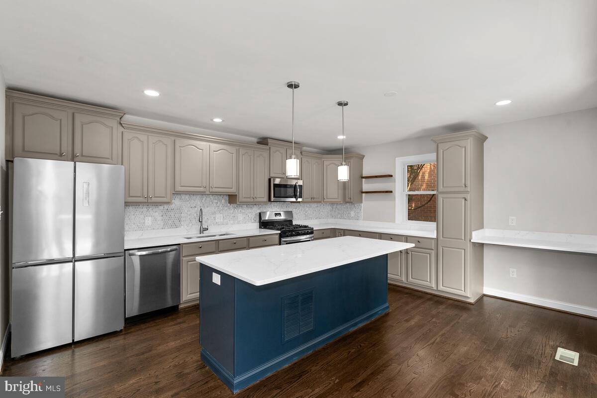 1506 Noyes Drive Silver Spring, MD 20910 - Photo 8 of 51 a kitchen with kitchen island a sink stainless steel appliances and cabinets