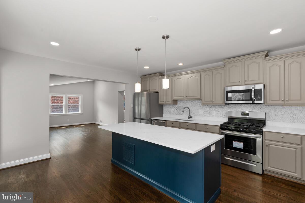 1506 Noyes Drive Silver Spring, MD 20910 - Photo 9 of 51 a kitchen with stainless steel appliances a stove top oven a sink dishwasher and a refrigerator with wooden floor