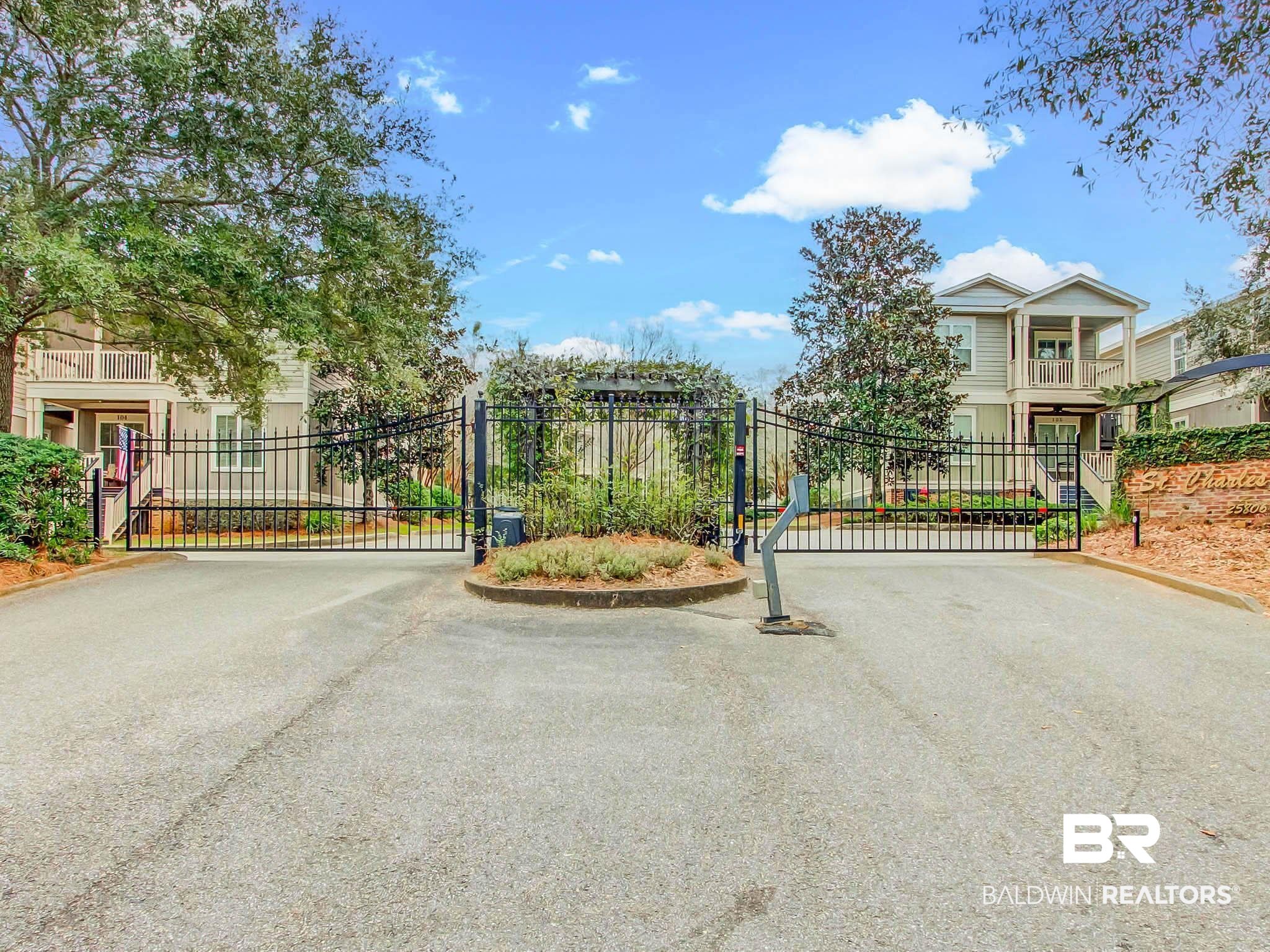 25806 Pollard Road, Unit 24 Daphne, AL 36526 - Photo 28 of 33 View of asphalt road with a gate, a gated entry, and curbs