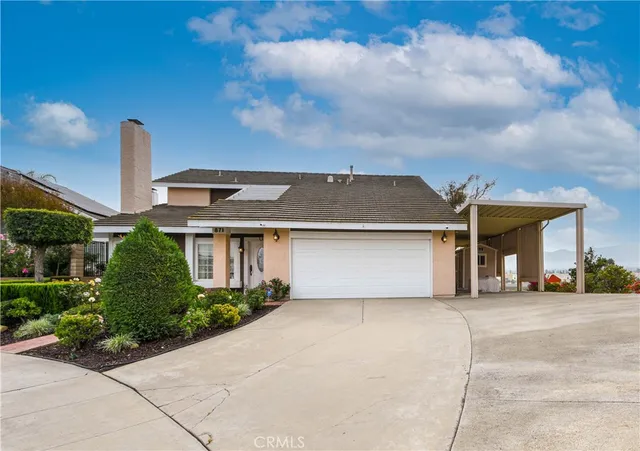 a front view of a house with a yard and potted plants
