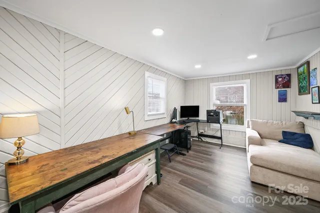 a living room with furniture flat screen tv and a large window
