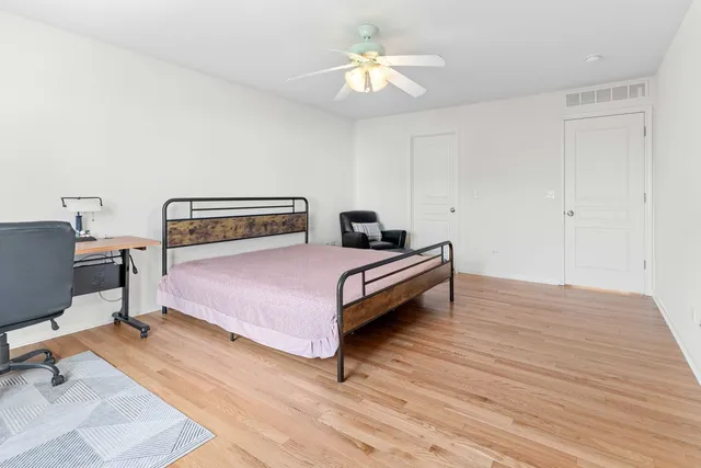 a bedroom with a bed wooden floor and a chandelier