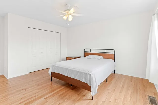 a bedroom with a bed and a ceiling fan