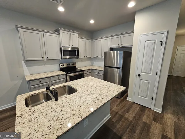 a kitchen with a refrigerator sink and microwave