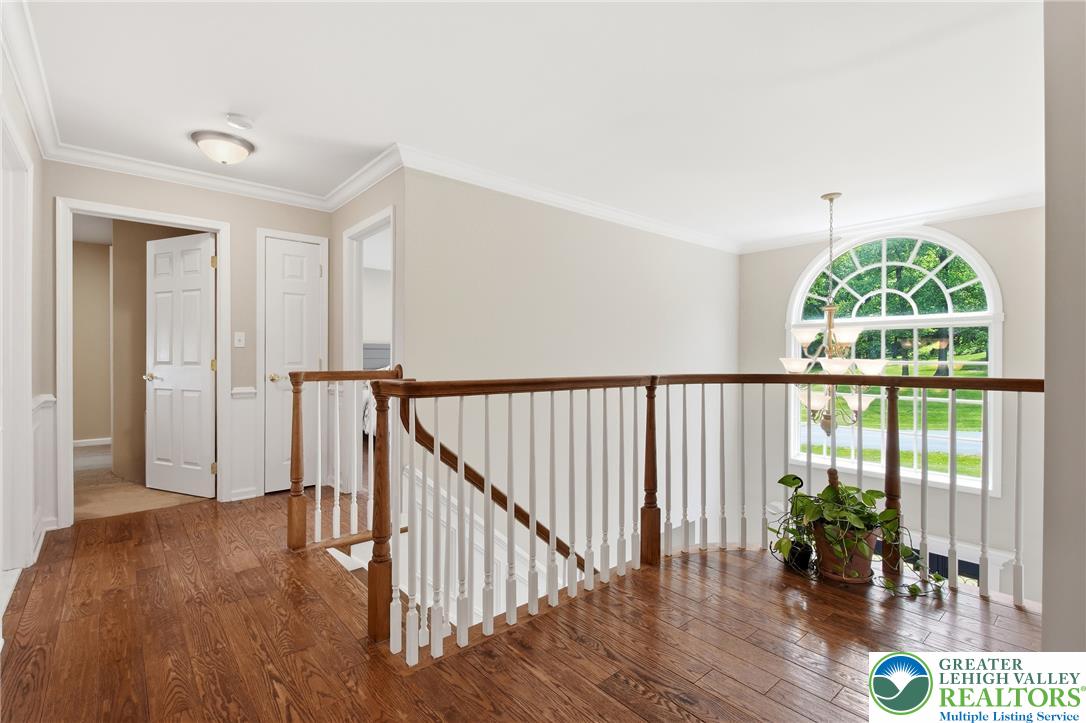 115 West Butternut Road Hellertown, PA 18055 - Photo 34 of 97 Natural light floods this inviting upper-level landing, showcasing rich hardwood flooring and elegant banister detailing.
