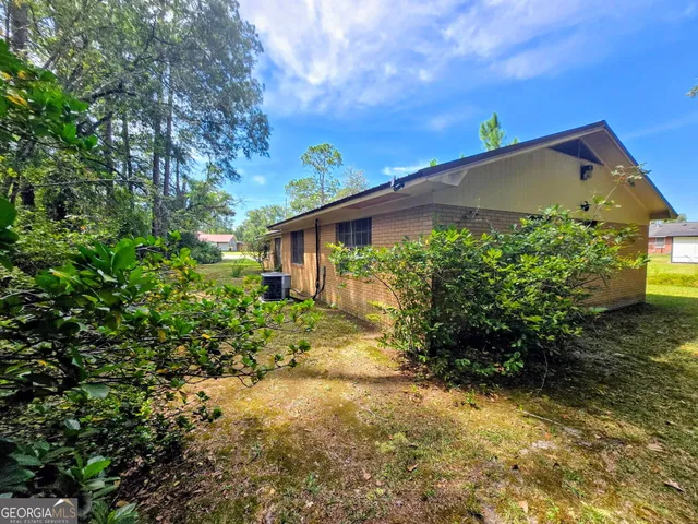 a backyard of a house with plants and tree