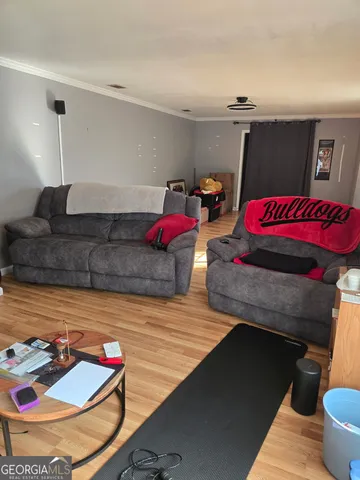 a living room with furniture and a wooden floor