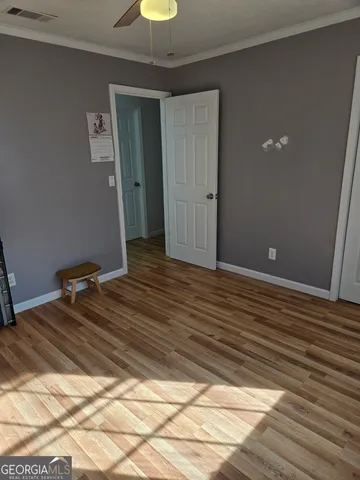 a view of a room with wooden floor and a ceiling fan