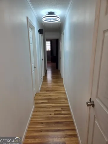 a view of a hallway with wooden floor and entryway