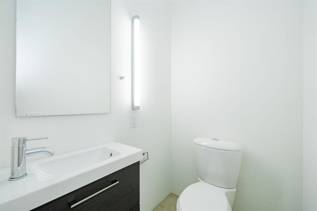2325 Rusk Place Dallas, TX 75204 - Photo 22 of 27 a bathroom with a sink a toilet and mirror